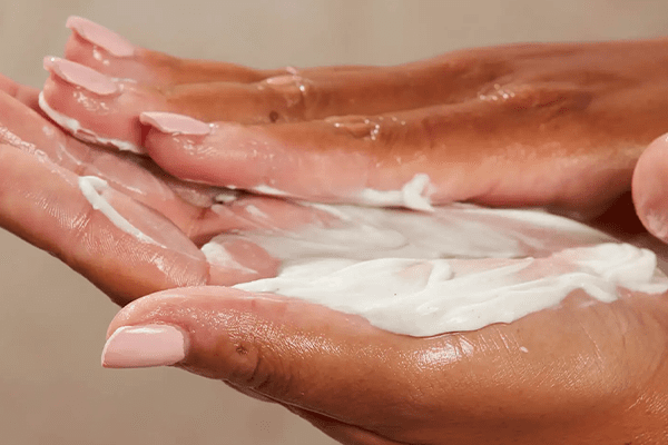 woman rubbing in hand cream