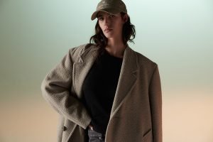 a model wearing a hat and a blazer shot in a studio