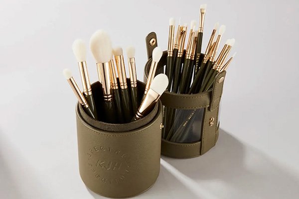A wide shot of Spectrum Collections’ KJH 25 Piece Brush Set displayed in its green, leather cylinder pot in a studio setting.