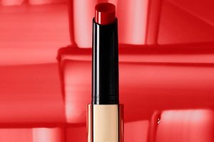 an hourglass lipstick balm in the red shade against a red background