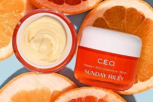 an orange sunday riley ceo moisturiser opened ontop of slices of oranges