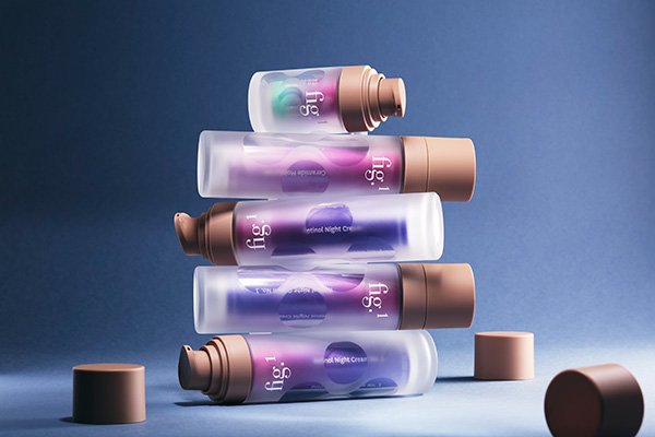 A product image of Fig.1 Beauty’s retinol bottles piled up on top of each other, in a studio setting on an ombre blue background.