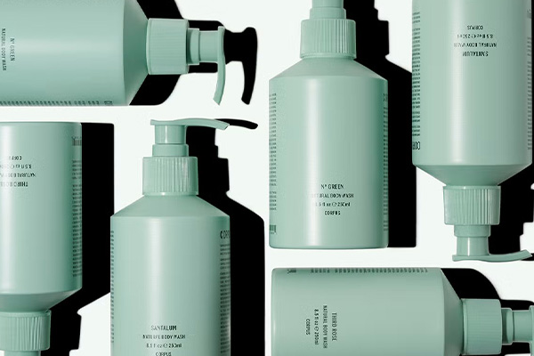 a collection of CORPUS body washes spread out on a white background positioned randomly. shot in a studio. the packaging is mint green