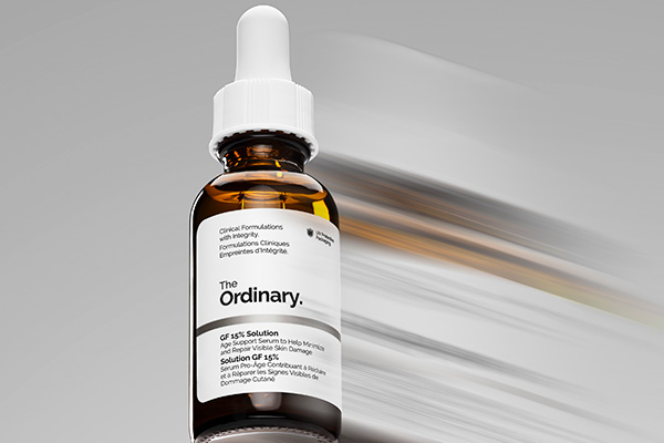 A zoomed in, blurred image of The Ordinary’s Growth Factors Solution 15% Serum, in a studio setting in front of a white background.