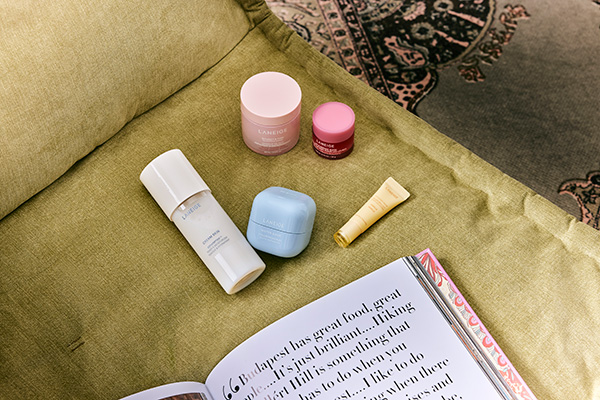 Laneige’s bestselling products laid across a fabric chair with a magazine in the corner, shot in a living room setting.