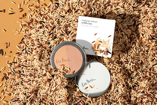 a product shot of Ere Perez's rice powder sat on a bed of rice with its packaging.