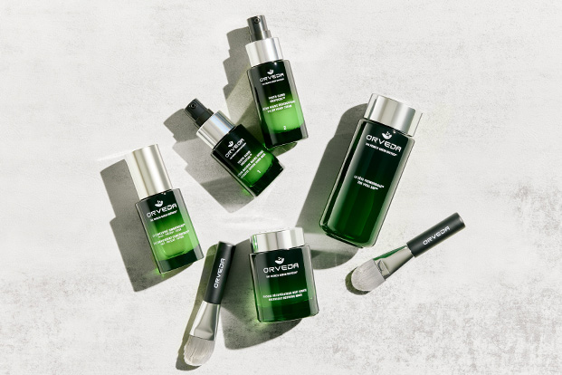 A flatlay image of all Orveda's bestselling skincare products laid out on a grey marble effect surface.