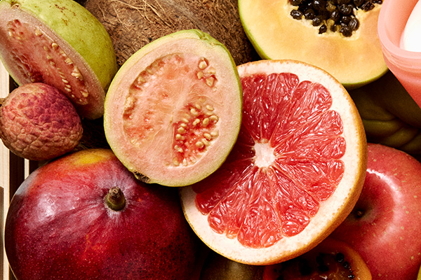 a box of fruit including grapefruit, pomegranet, coconuts and melons
