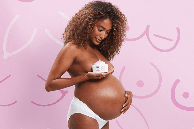 Pregnant model holding mama mio pink tummy rub butter