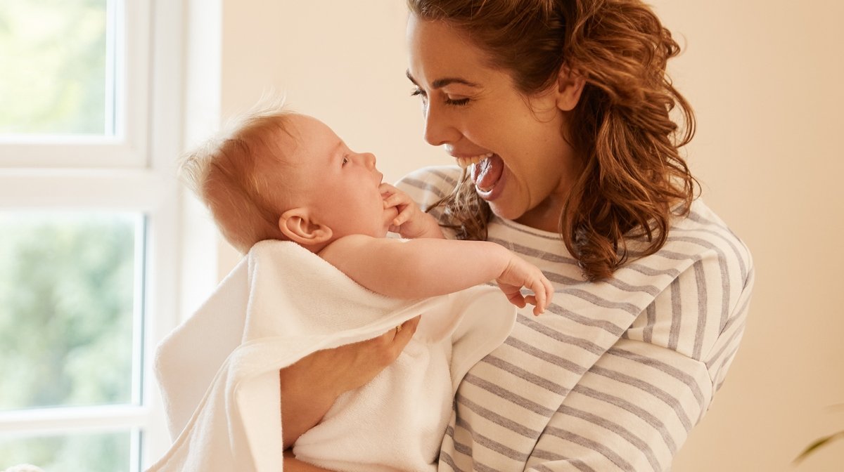 mother holding baby and laughing