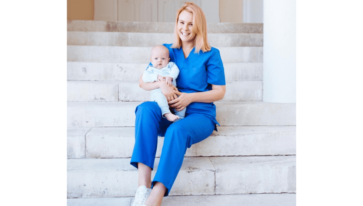 midwife vic on steps holding a baby