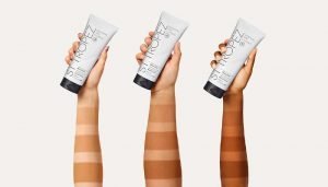 three different skin toned arms holding onto the st tropez gradual tan with three streaks each showing the tan getting darker