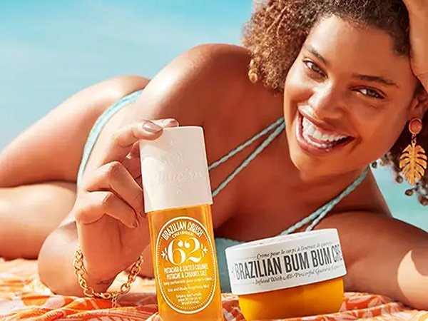 model on a beach with two sol de janiero products next to her