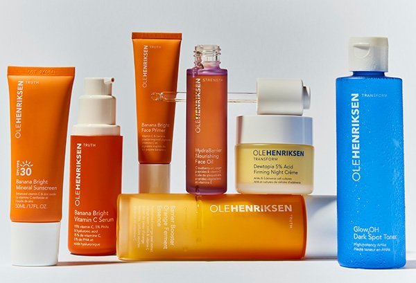A selection of OLE HENRIKSEN products (including the Banana Bright Vitamin C Serum) against a grey-ish white studio background