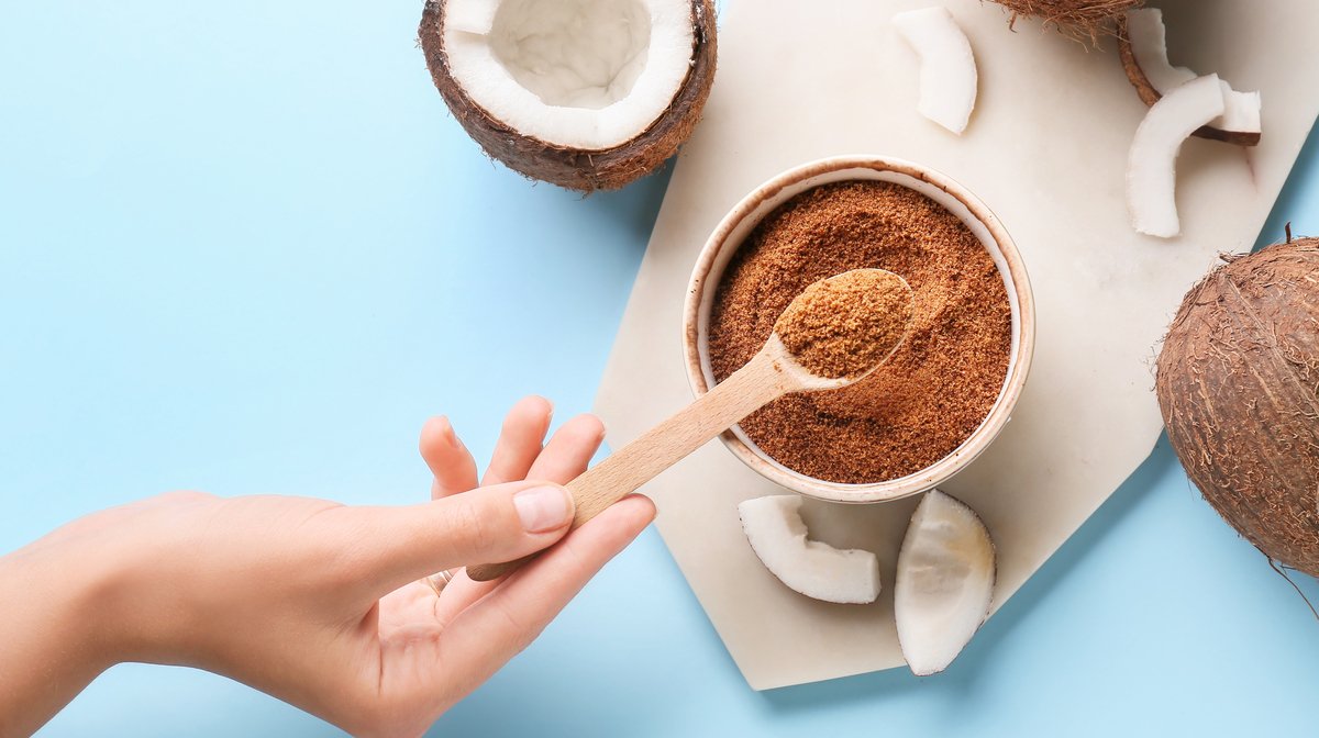 hand holding a spoon with coconut sugar