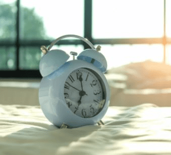 Alarm clock on the bed. 