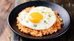 A plate of Kimchi fried rice, a popular Korean dish made with fermented cabbage, rice, and various vegetables.