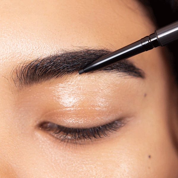 Defining and styling brows with a brow pencil and spoolie