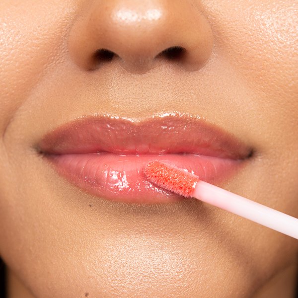 Applying lip gloss to lips