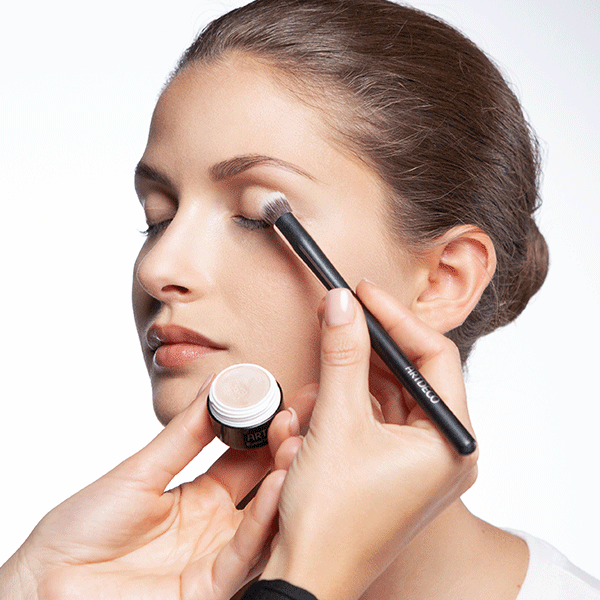 Apply an eyeshadow base using a compact brush