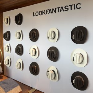 A white wall decorated with cowboy hats and the LOOKFANTASTIC logo.