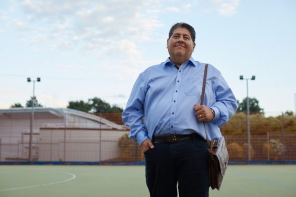 An obese man standing on the football field.