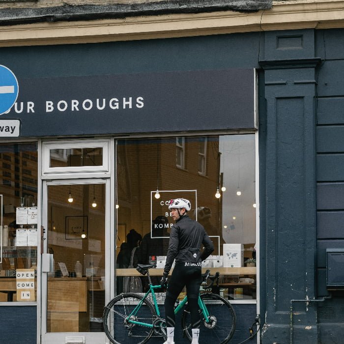 A cyclist outside a cafe with their bike