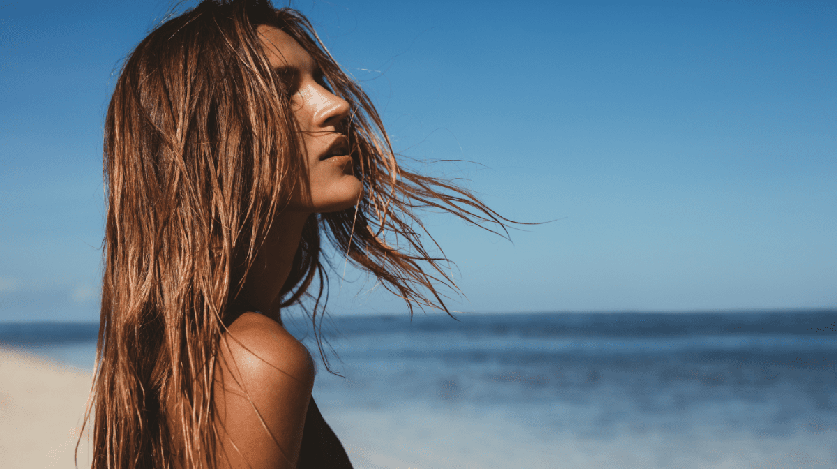 Woman on beach with hair blowing in the wind