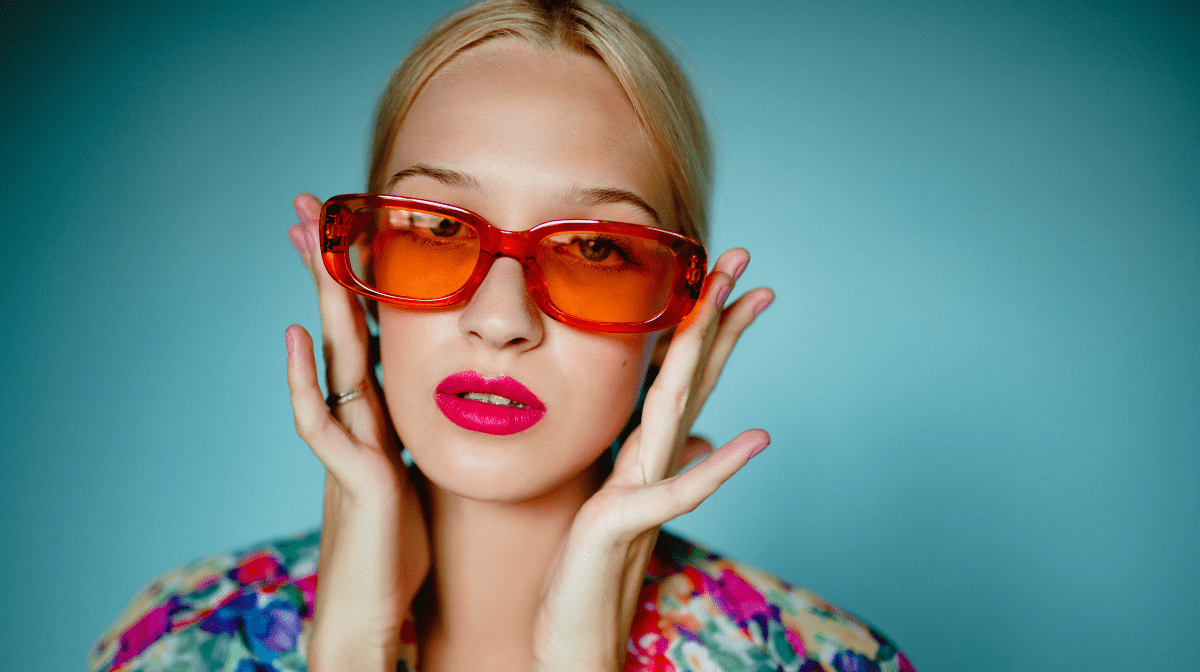 Woman wearing a bold lipstick colour with sunglasses