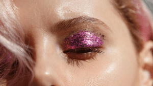 A close up of a woman's glittery eye makeup