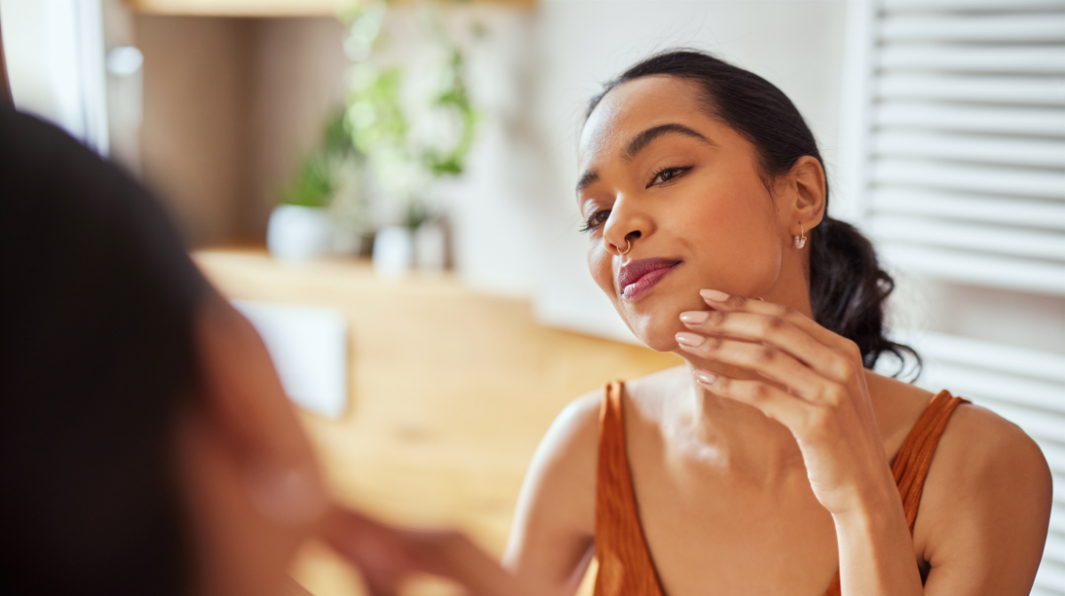 Woman looking at her makeup in the mirror.