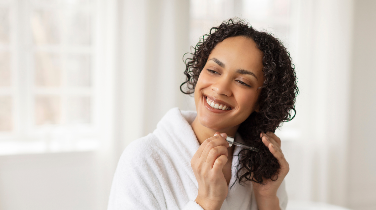 Woman applying hair oil.