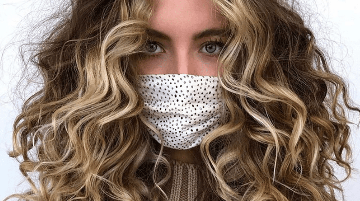 Curly haired girl wearing COVID-19 pandemic mask