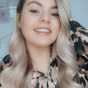 Grow Gorgeous team member Maddy, smiling with ash toned blonde curled hair. Hair that makes her feel beautiful.