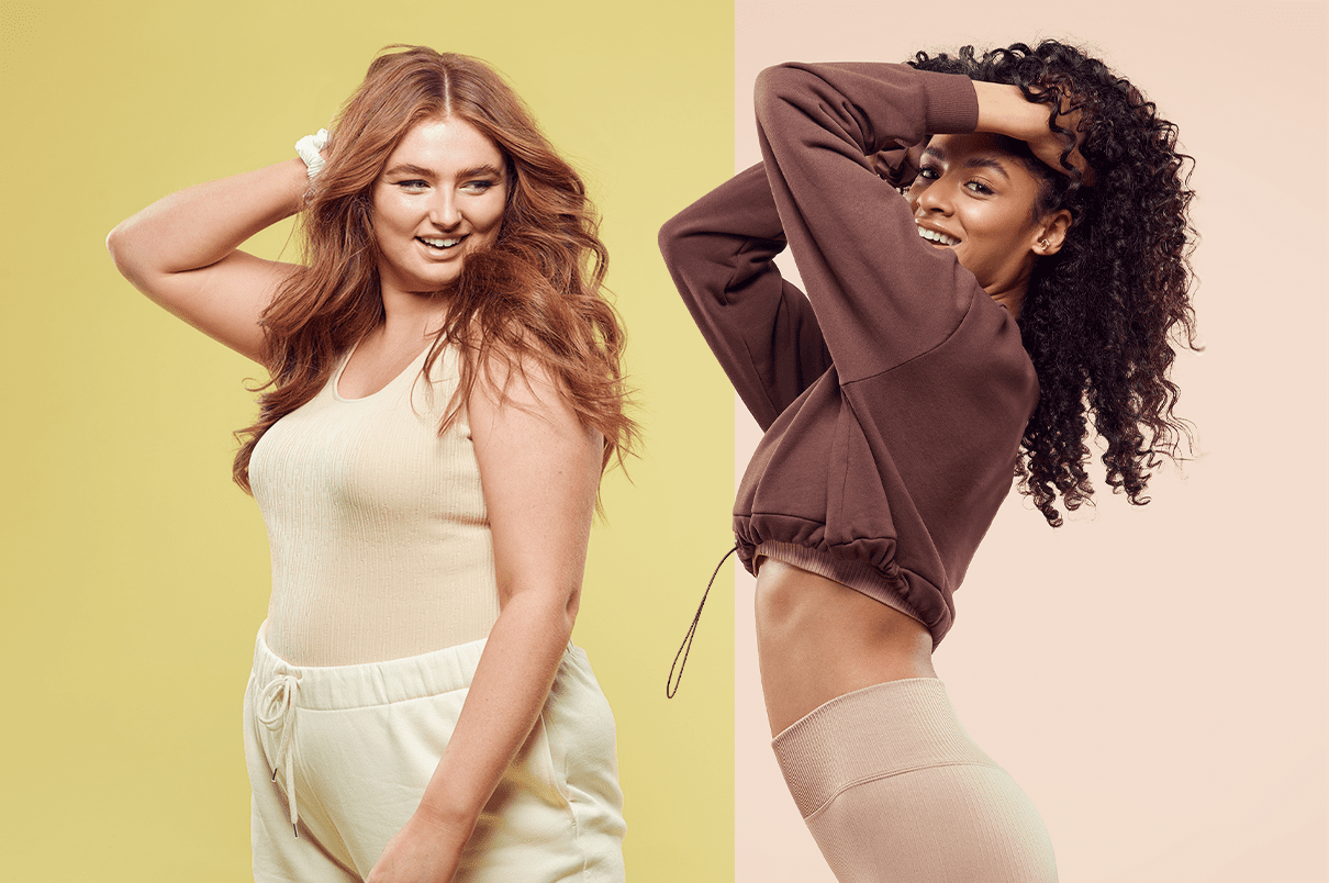 Two women smiling with their hands up touching their heads. The background colours are split in two: yellow and brown.