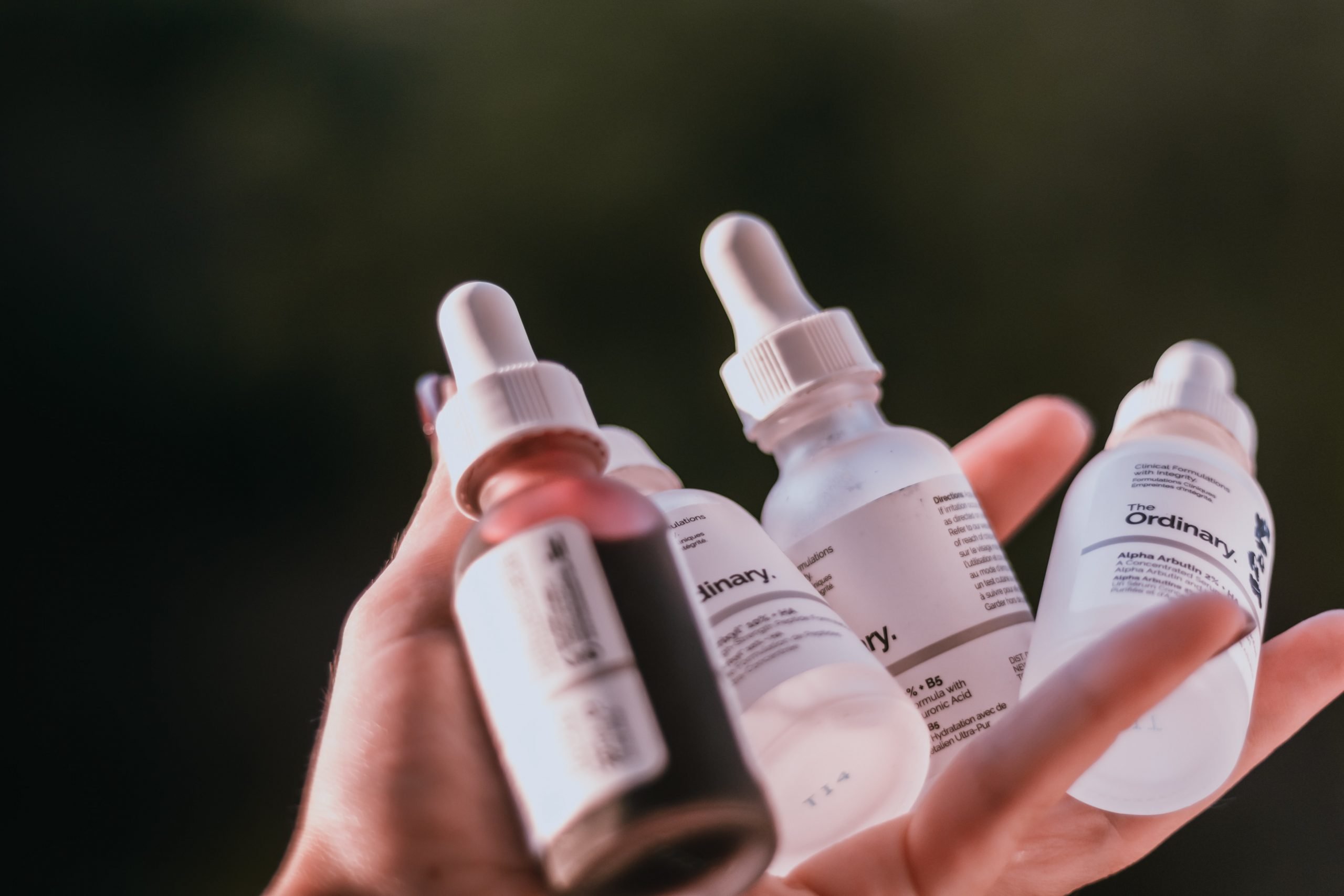 girl holding an assortment of facial serums and oils from The Ordinary