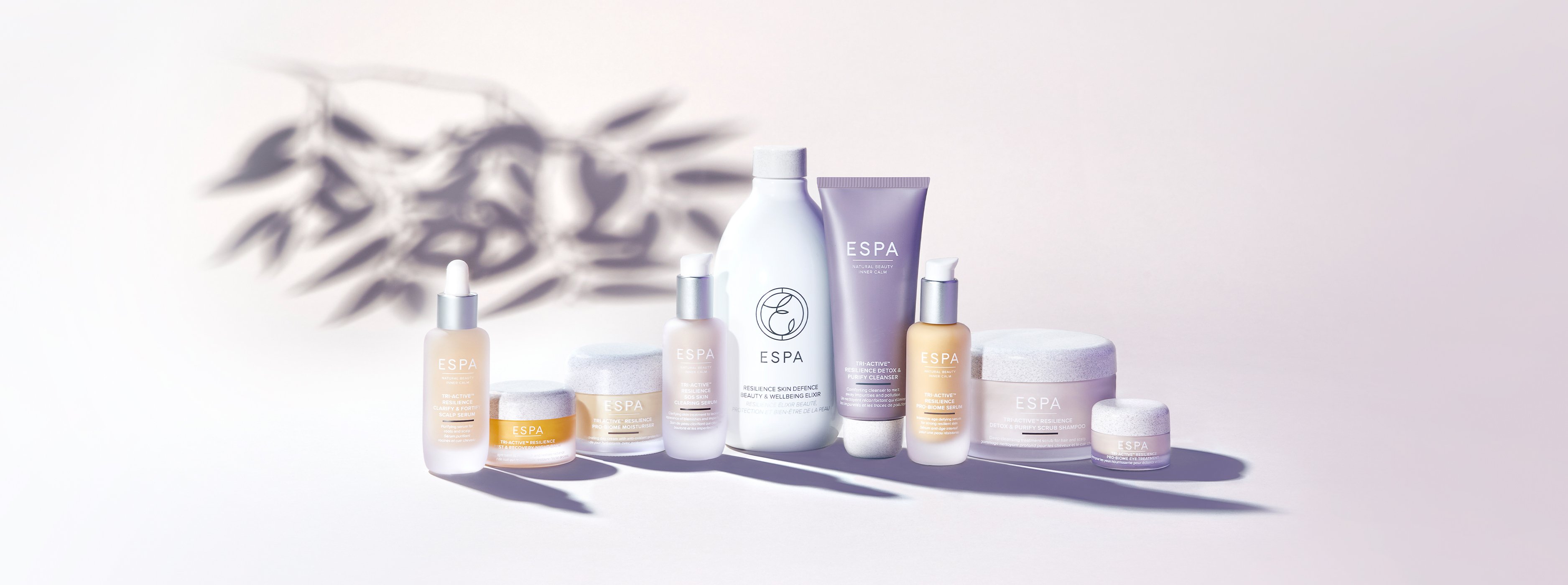 ESPA products in a row with a plant reflection