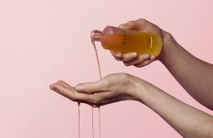 woman pouring massage oil into hands