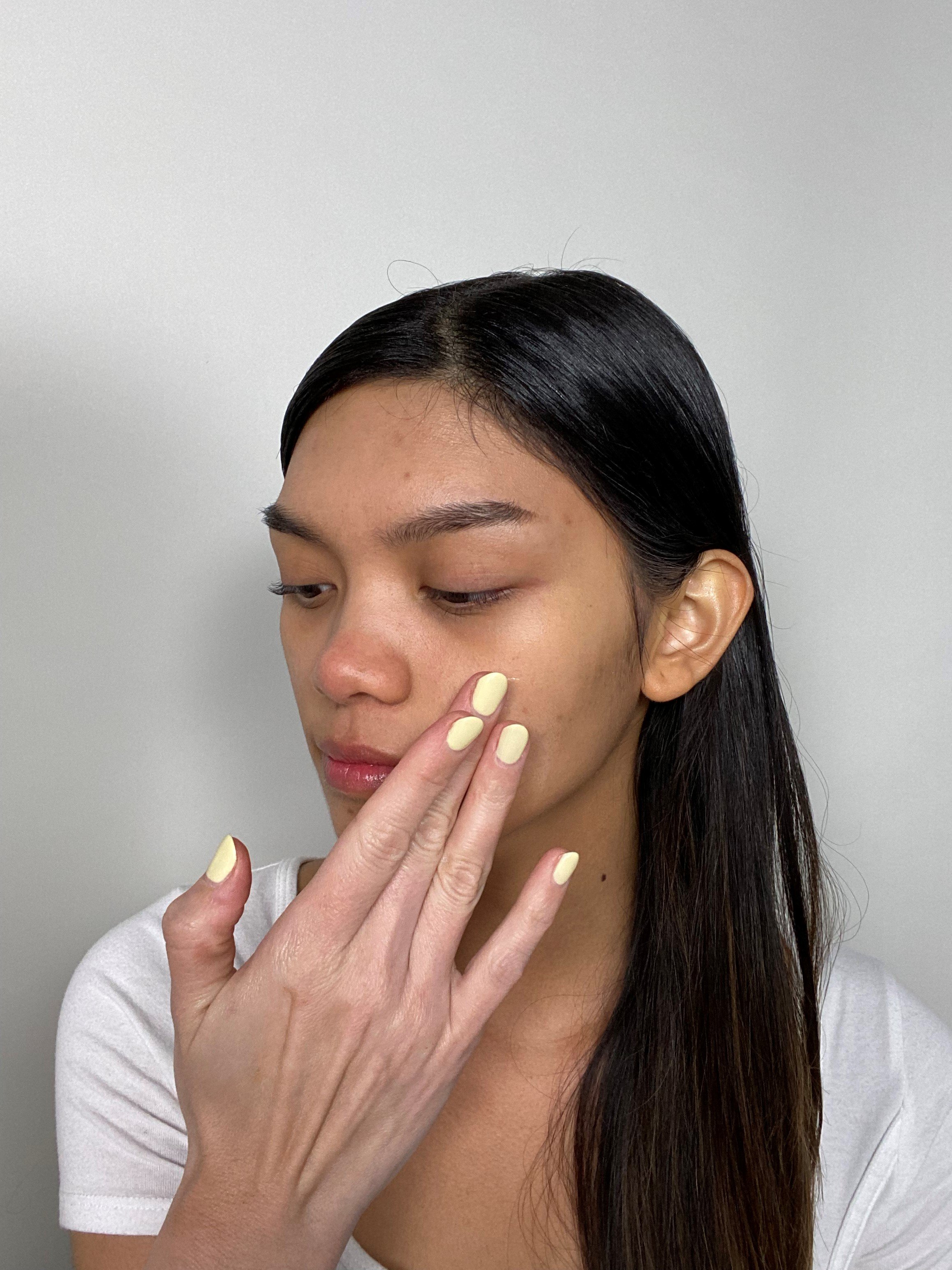 girl applying primer onto face