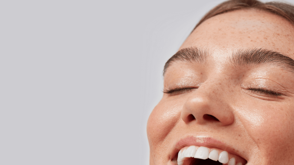 Woman smiling using Off In A Blink Eye Makeup Remover