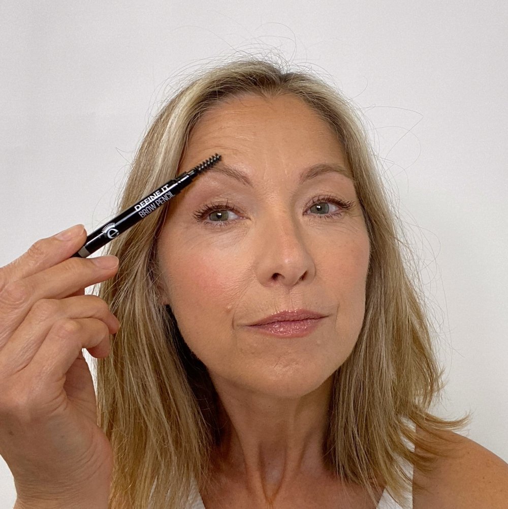 woman combing thin eyebrows upwards