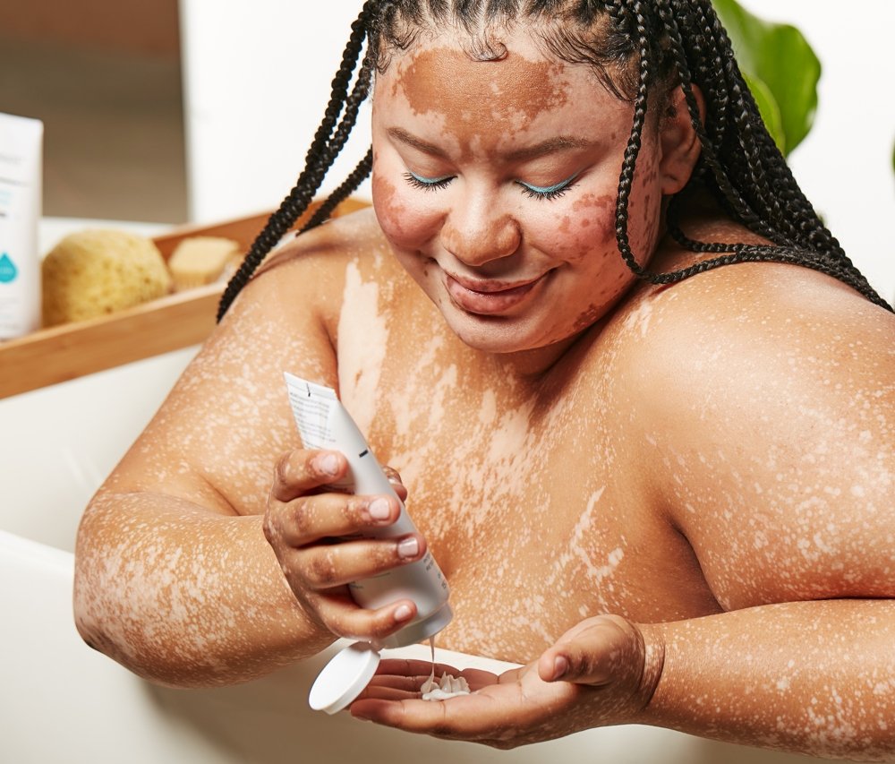 woman exfoliating body in bath