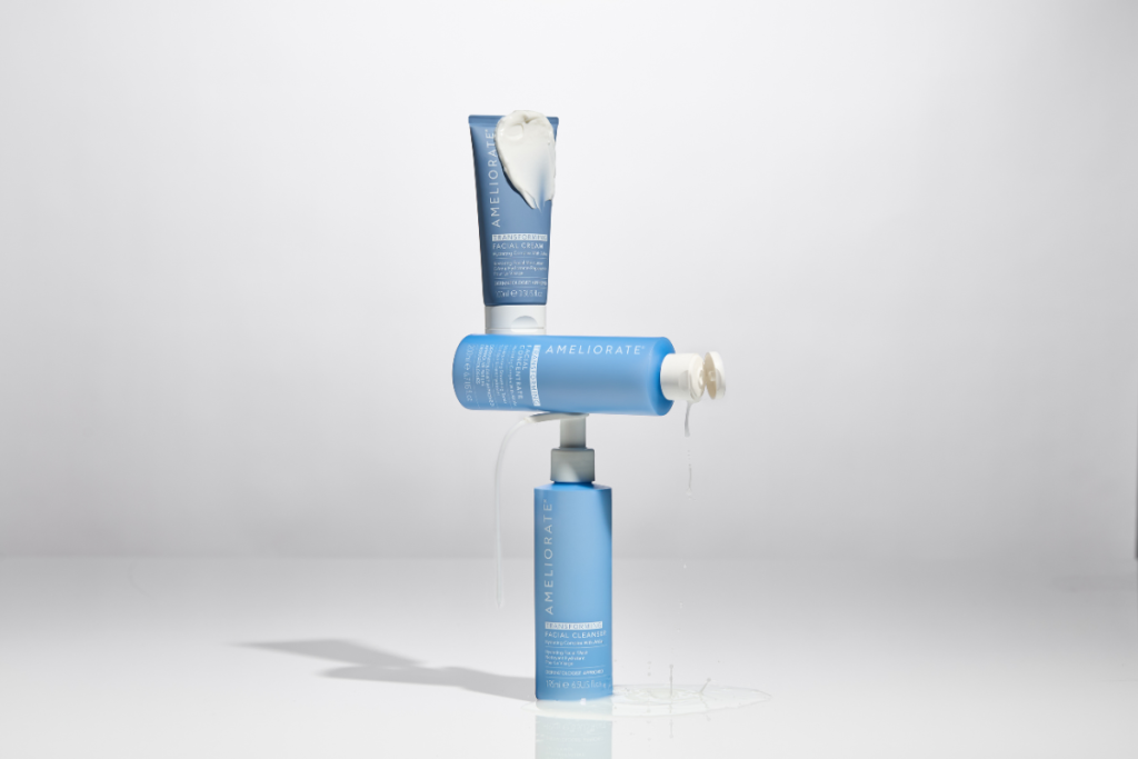 AMELIORATE facial skincare range with cleanser, cream, and exfoliant on white background