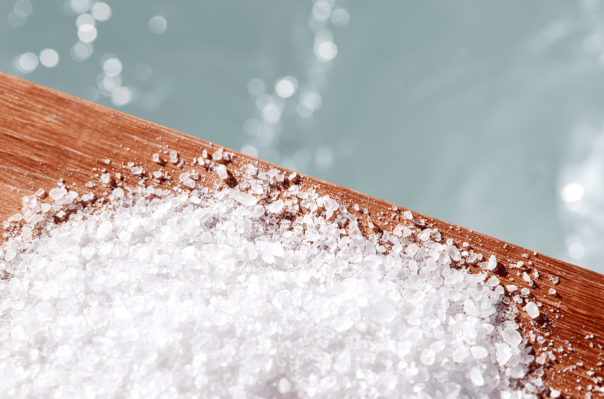 The natural hair ingredient salt shown placed on top of a wooden table.