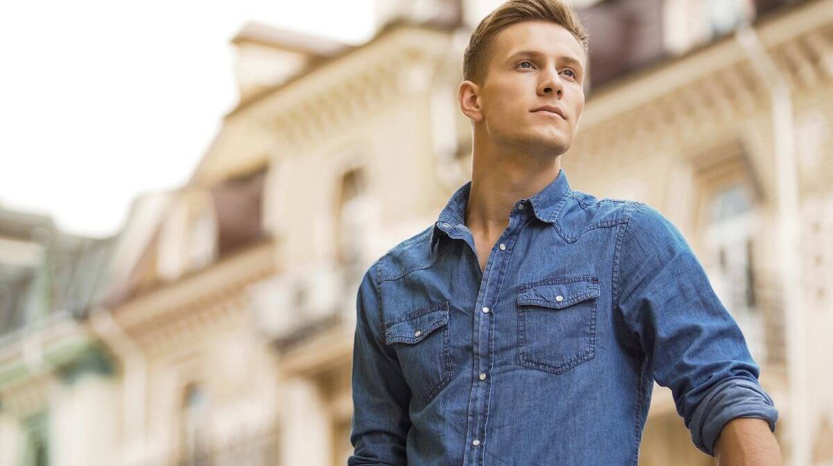 man wearing a denim shirt with rolled-up sleeves