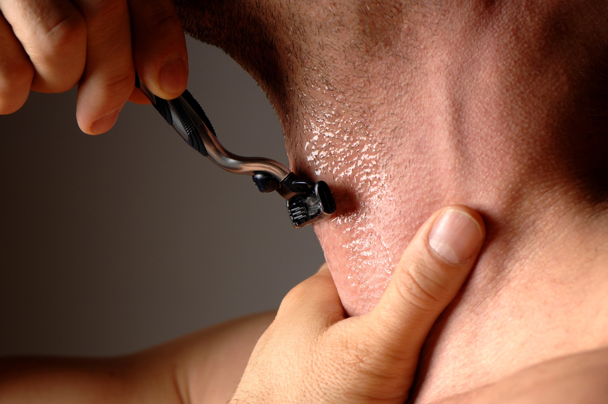 man shaving neck against the grain with Gillette razor