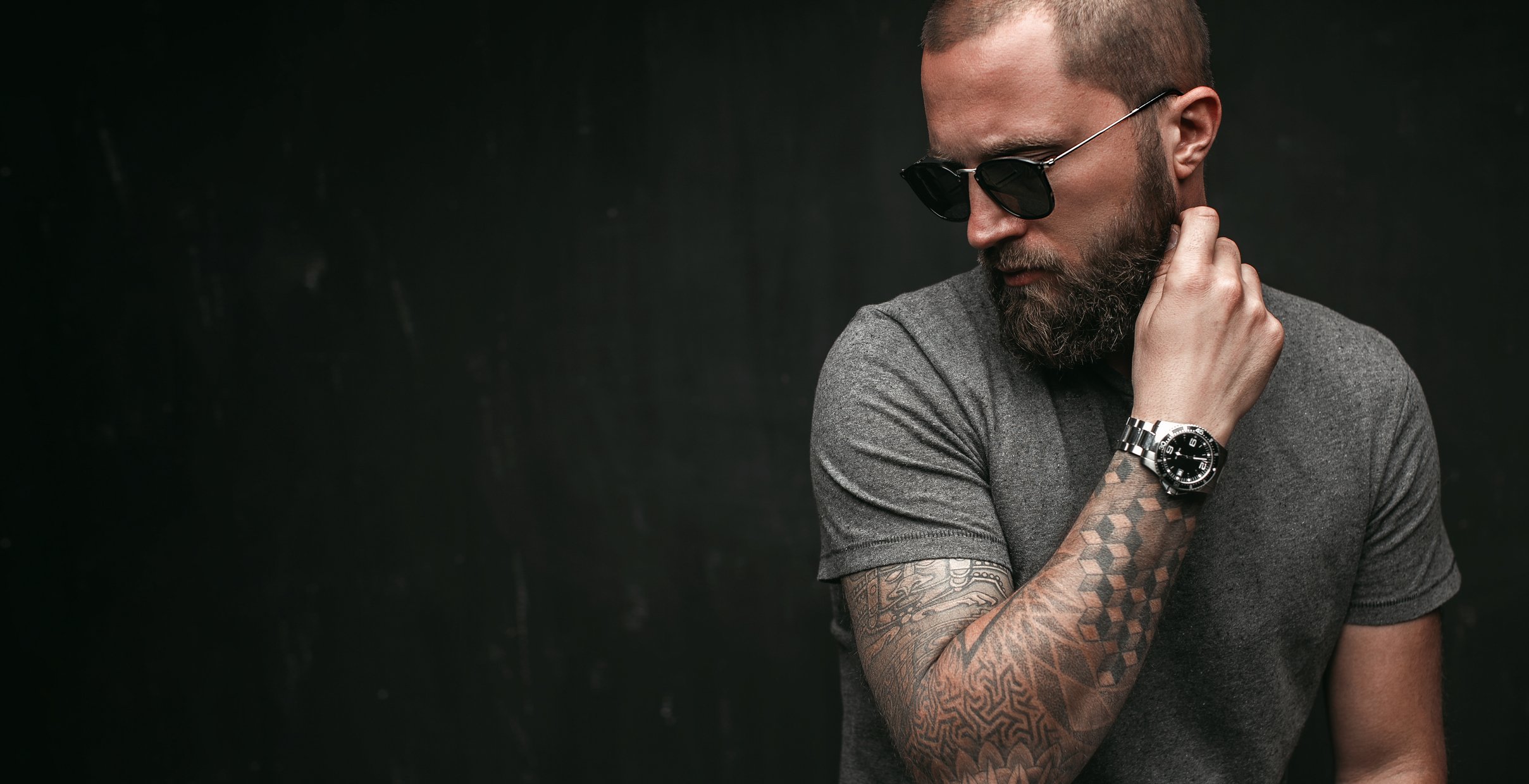 tattooed man wearing sunglasses indoors