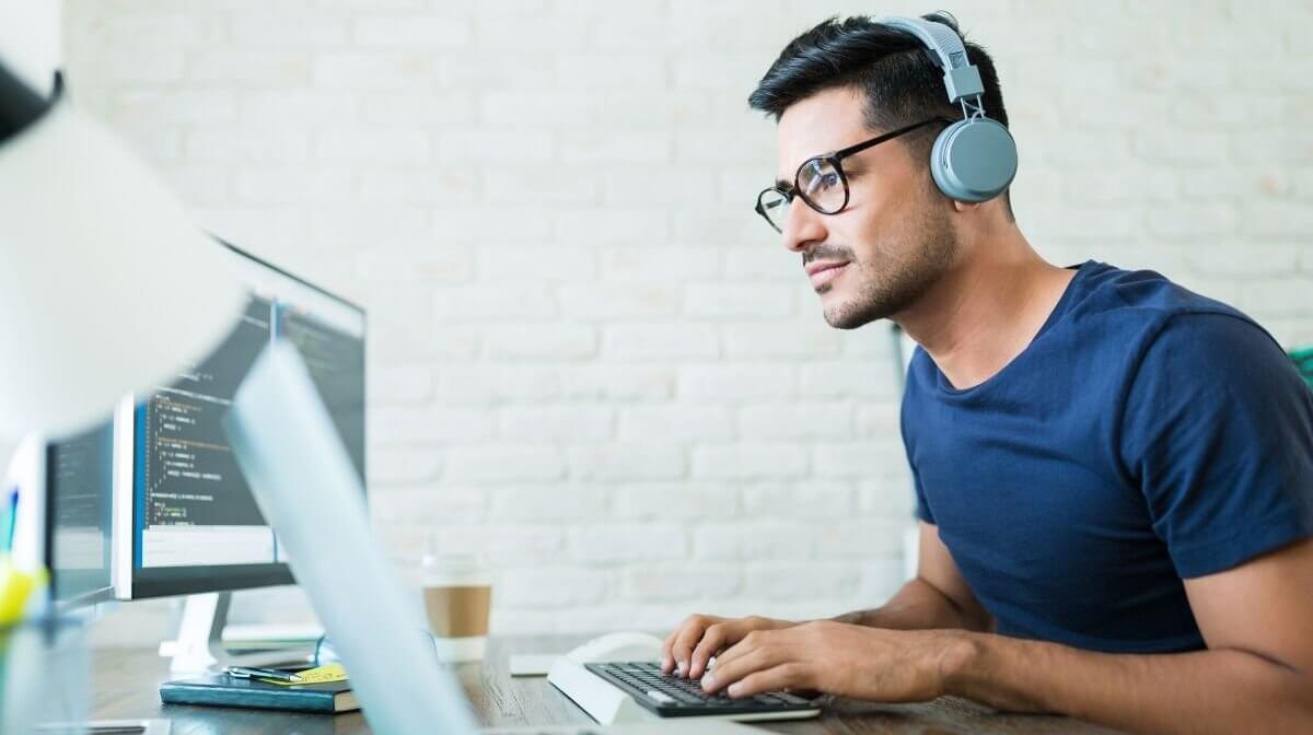 man using headphones to maintain focus while working from home