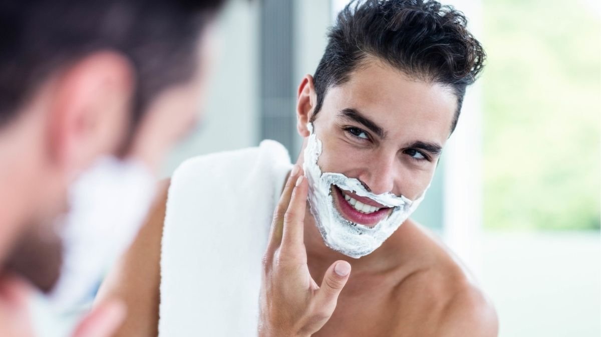 young man shaving in front of the mirror