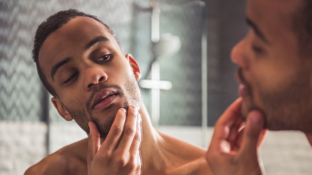 A man looks at his 5 o'clock shadow in the mirror | Gillette UK